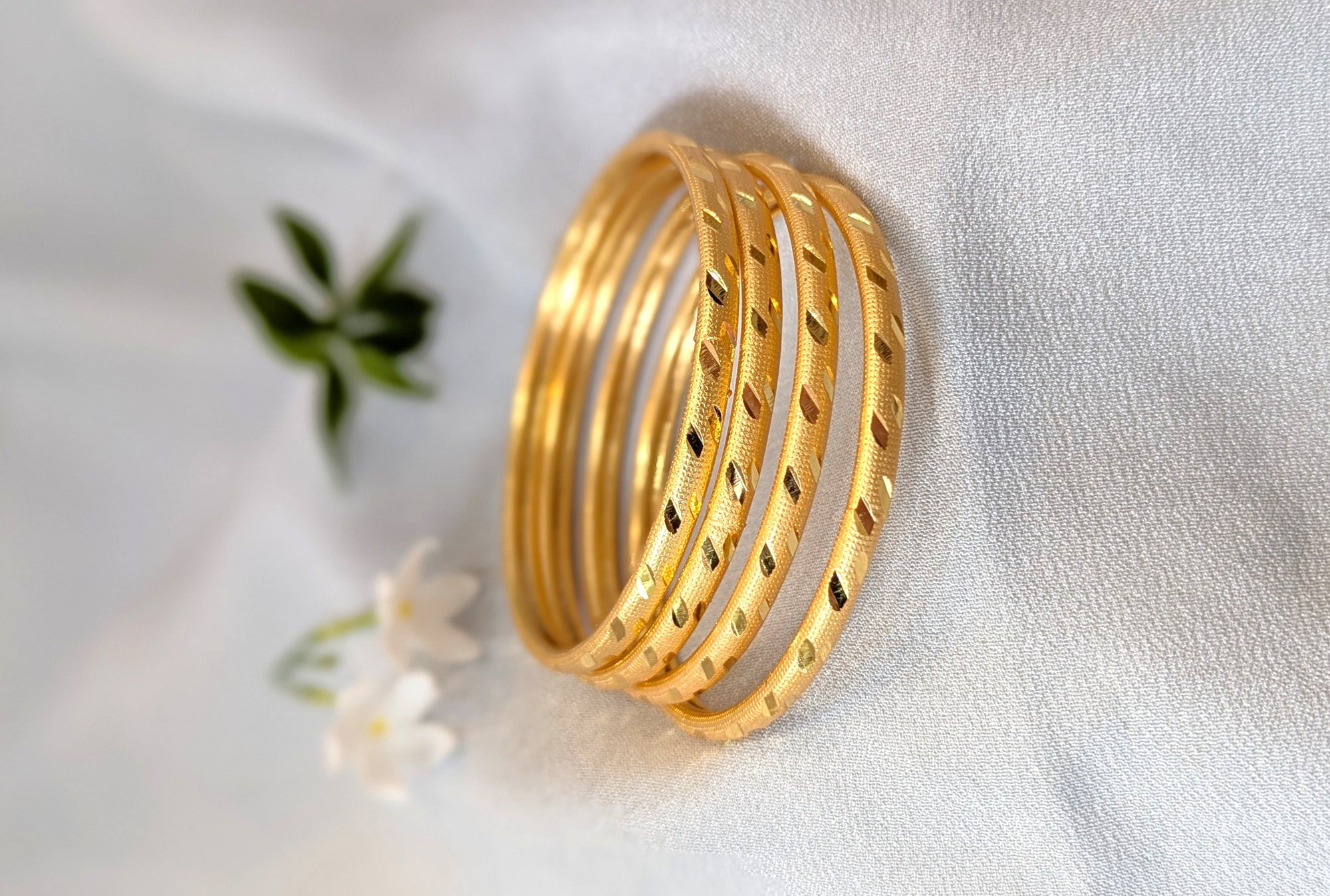 Set of gold bangles on a light fabric background
