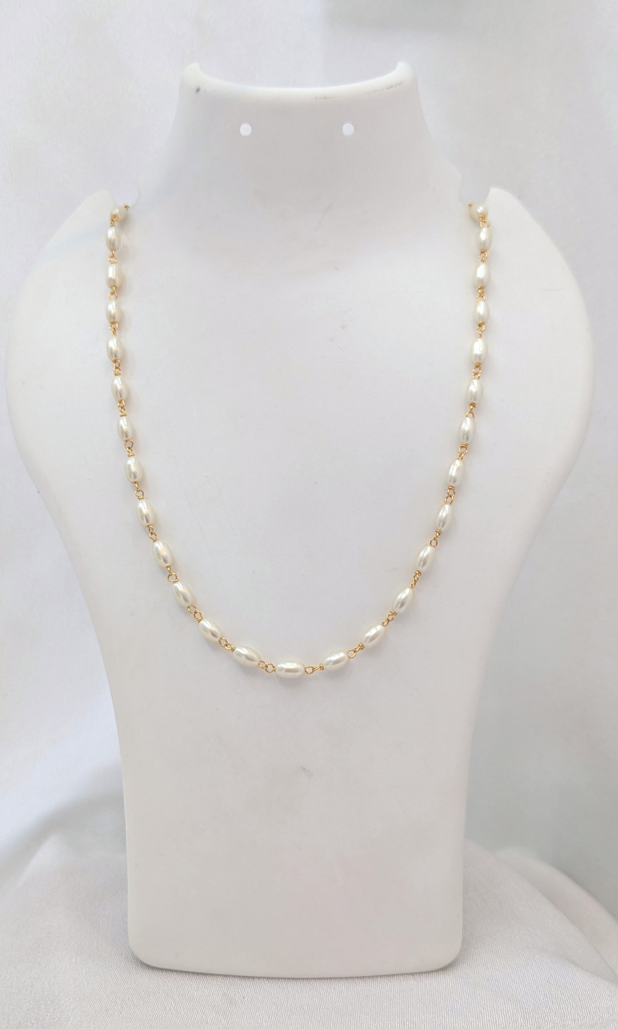 Gold chain necklace on a white mannequin bust